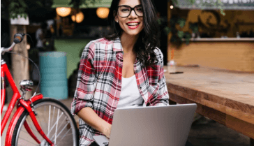 A student uses her laptop, smiling